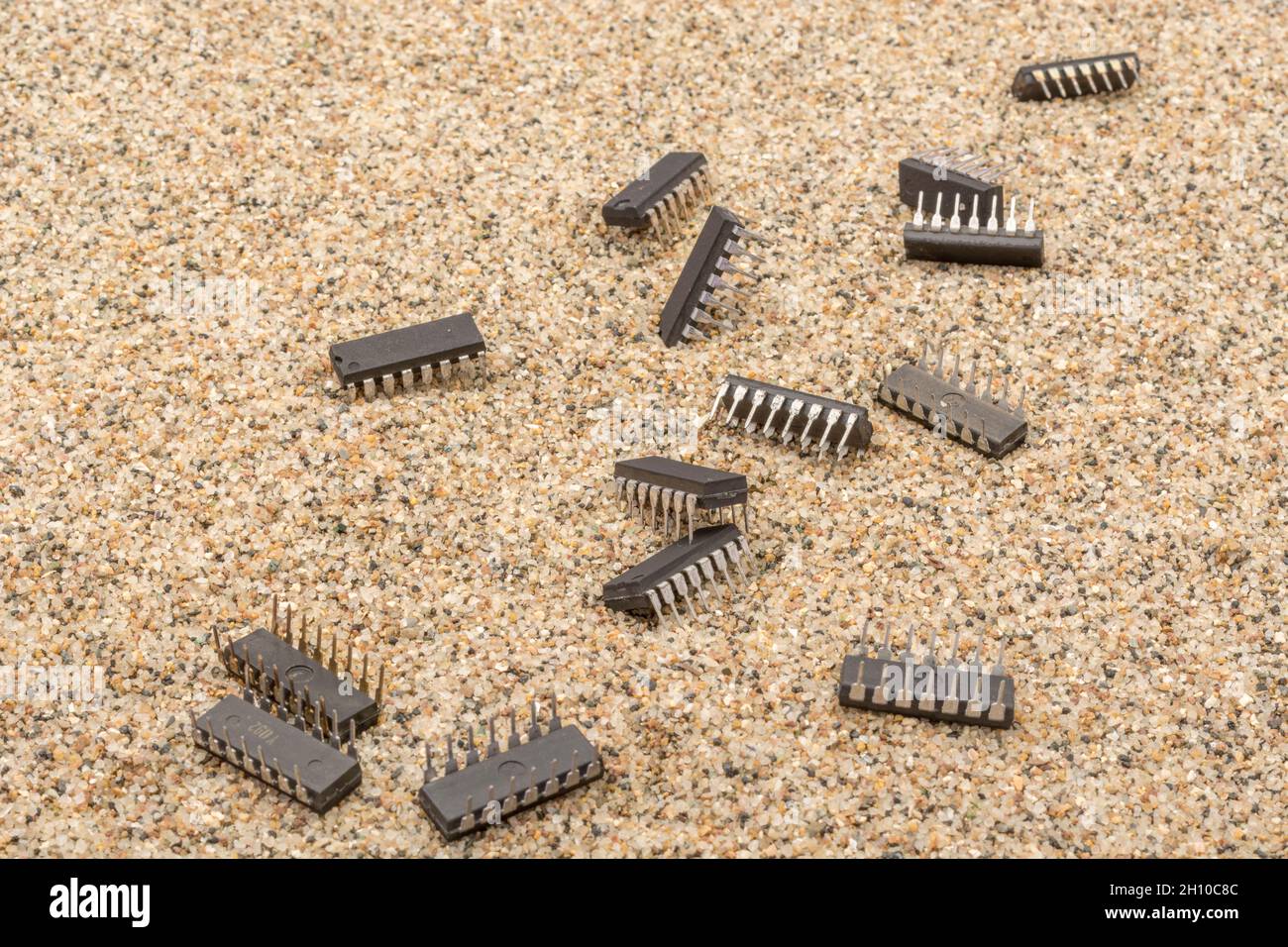 Mikrochips oder IC-Chips (integrierte Schaltung) in Sand vergraben. Für IC/Halbleiter, Chipknappheit in Russland, Mikrochip-Industrie + CHIPS for America Act Stockfoto