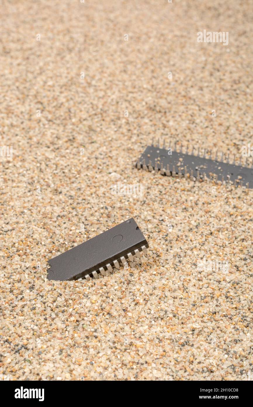 Mikrochips oder IC-Chips (integrierte Schaltung) in Sand vergraben. Für IC/Halbleiter, Chipknappheit in Russland, Mikrochip-Industrie + CHIPS for America Act Stockfoto