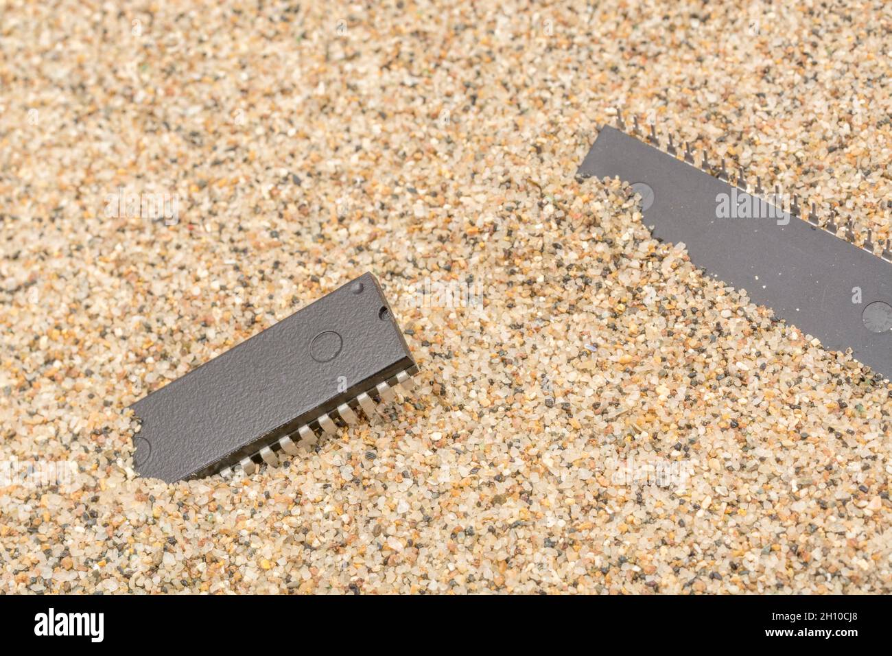 Mikrochips oder IC-Chips (integrierte Schaltung) in Sand vergraben. Für IC/Halbleiter, Chipknappheit in Russland, Mikrochip-Industrie + CHIPS for America Act Stockfoto