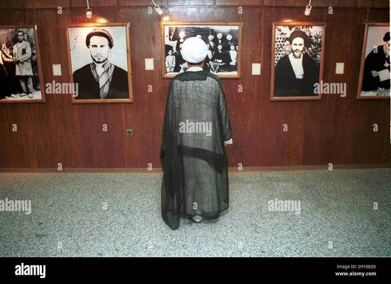 Ein Mann, der historische Bilder an einer Wand ansieht. Iran. Stockfoto