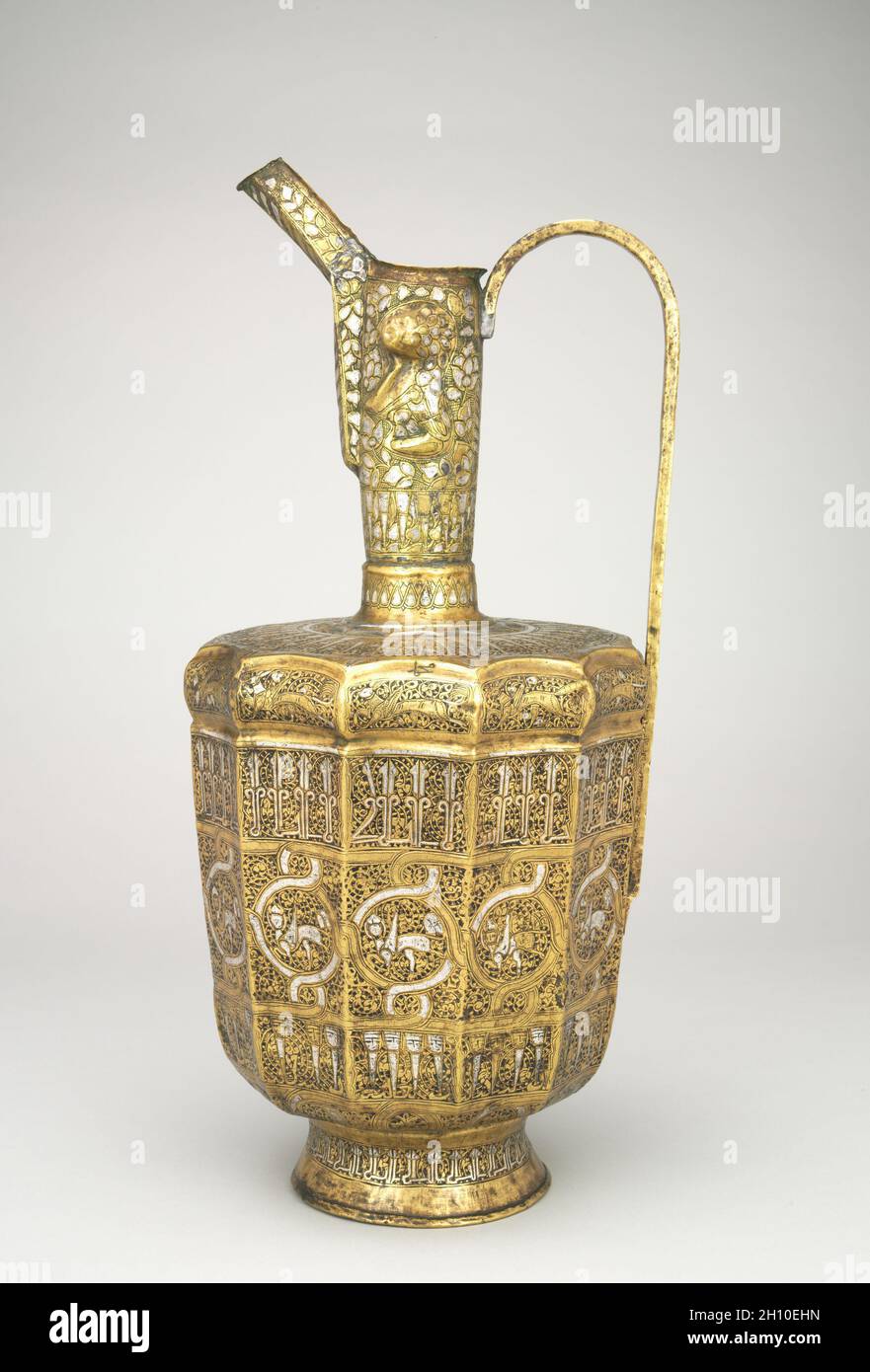 Zwölfseitiges Ewer mit Sphinxen und menschkopfigen Inschriften, 1300–1350. Iran, Khurasan, Ilkhanid-Zeit (1256–1353). Gehämmertes Messingblech mit Silbereinlegeplatte; insgesamt 44.8 cm (17 5/8 in.). Stockfoto