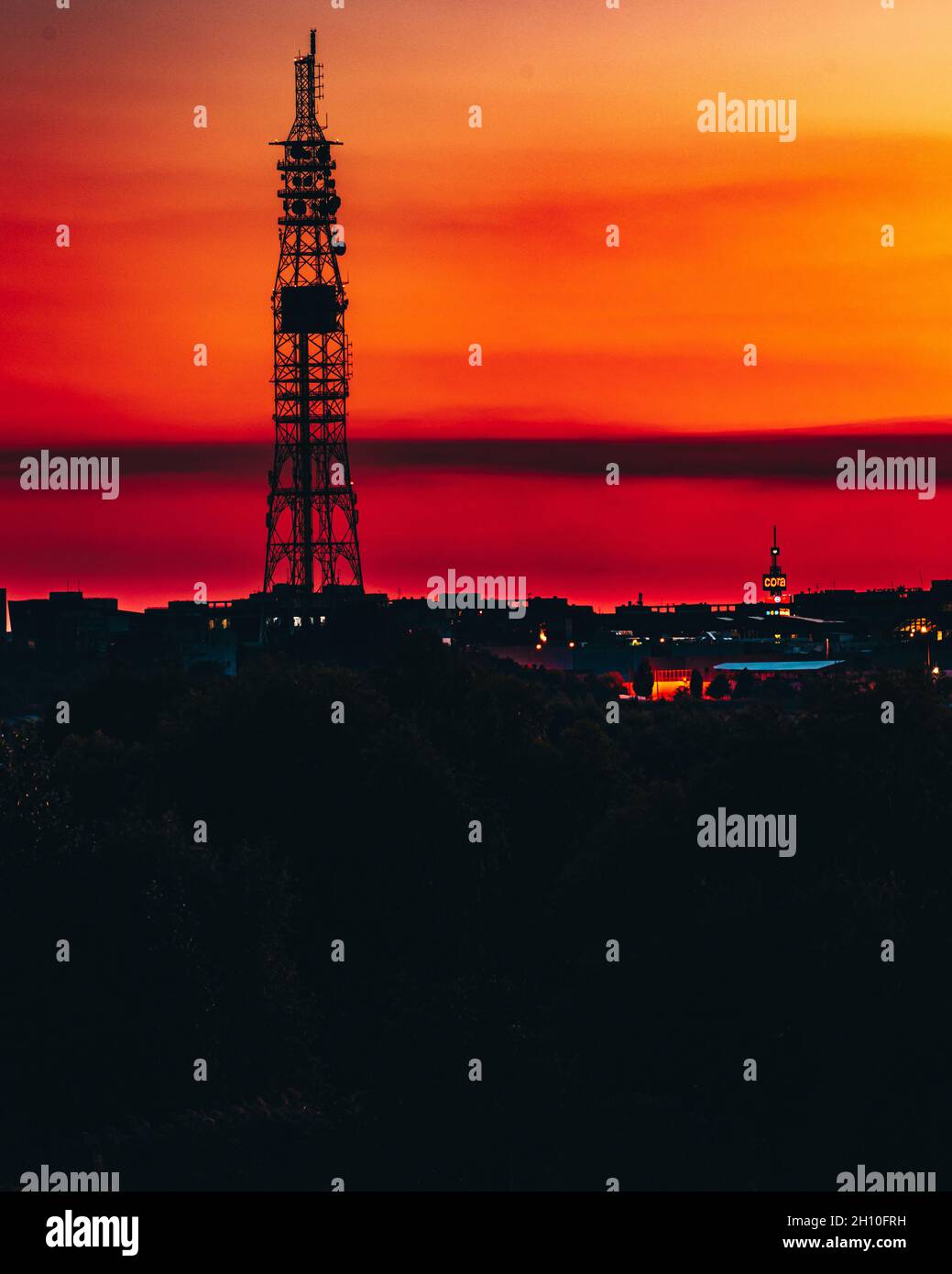 Ruhige Landschaft einer Silhouette eines Leuchtturms in orange und violettem Ombre Himmel bei goldenem Sonnenuntergang Stockfoto