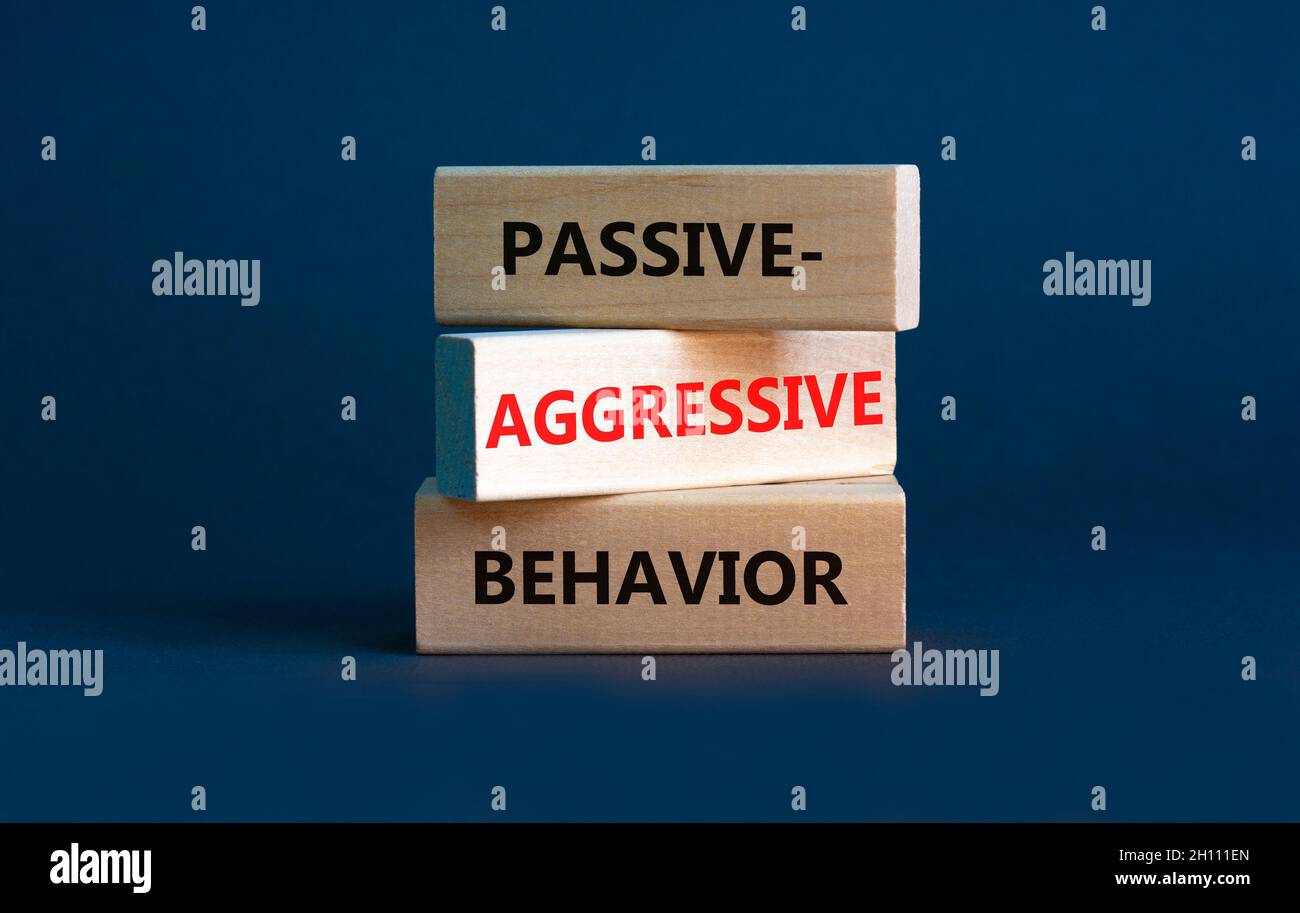 Passiv-aggressives Verhaltenssymbol. Konzeptwörter Passiv-aggressives Verhalten auf Holzblöcken. Schöner grauer Hintergrund. Business, passiv-aggressiv Stockfoto