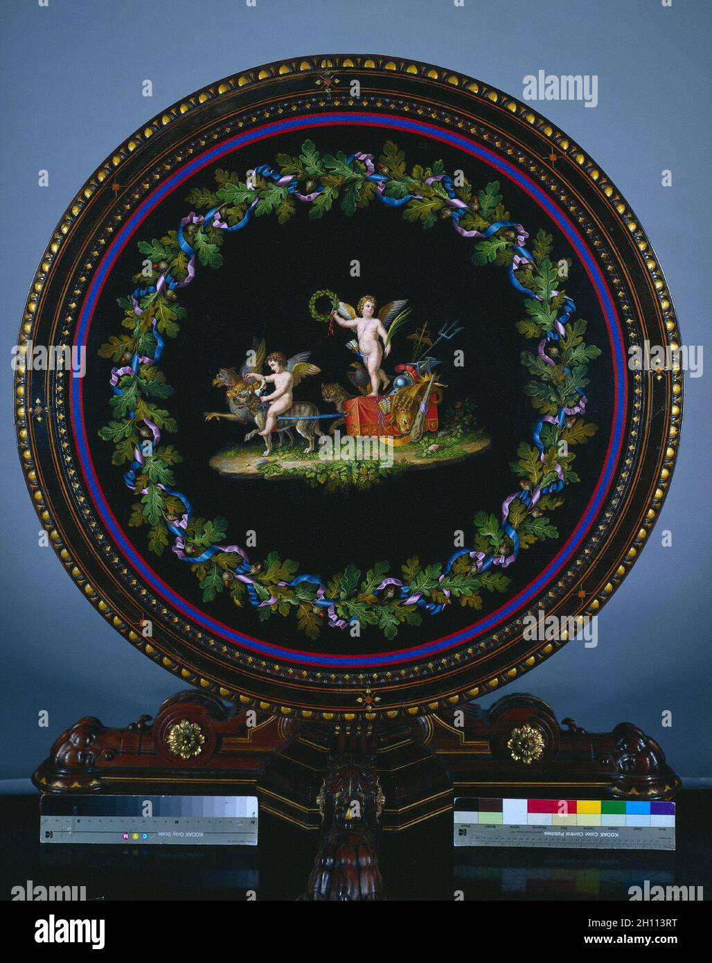 Mitteltisch mit Micromosaic Top, 'Love Triumphor', Tisch c. 1865; Oberseite c.1830-50. Agostino Francesangeli (italienisch), Herter Brothers (amerikanisch) zugeschrieben. Nussbaum mit vergoldeten Metallhalterungen, eingelegtem Ornament und Mikromosaik-Oberseite; insgesamt 76.2 x 108.5 cm (30 x 42 11/16 Zoll). Stockfoto