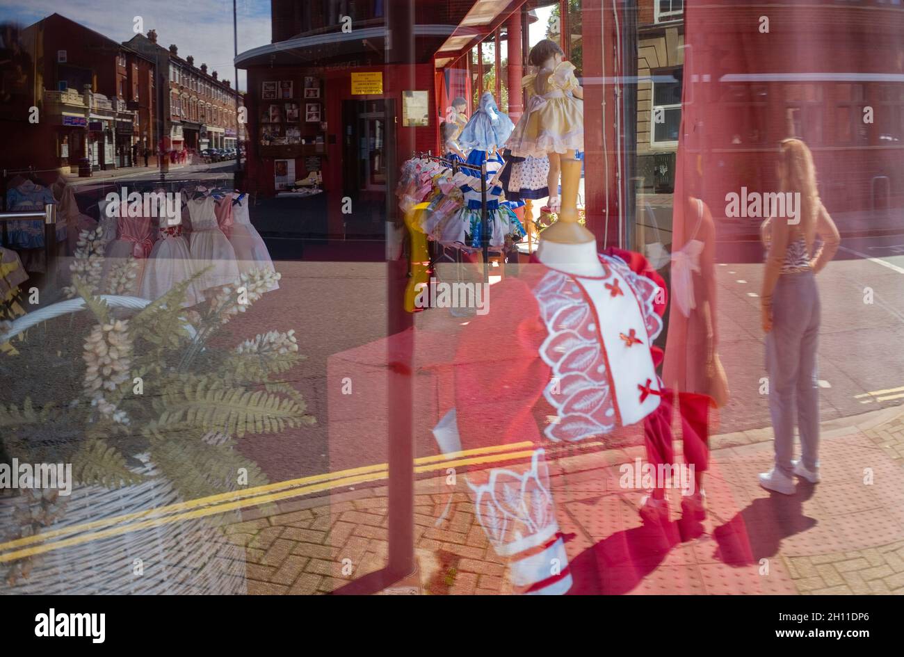 Blick und Reflektionen aus dem Fenster eines Kleiderladens, der nur Rüschen für junge Mädchen verkauft Stockfoto
