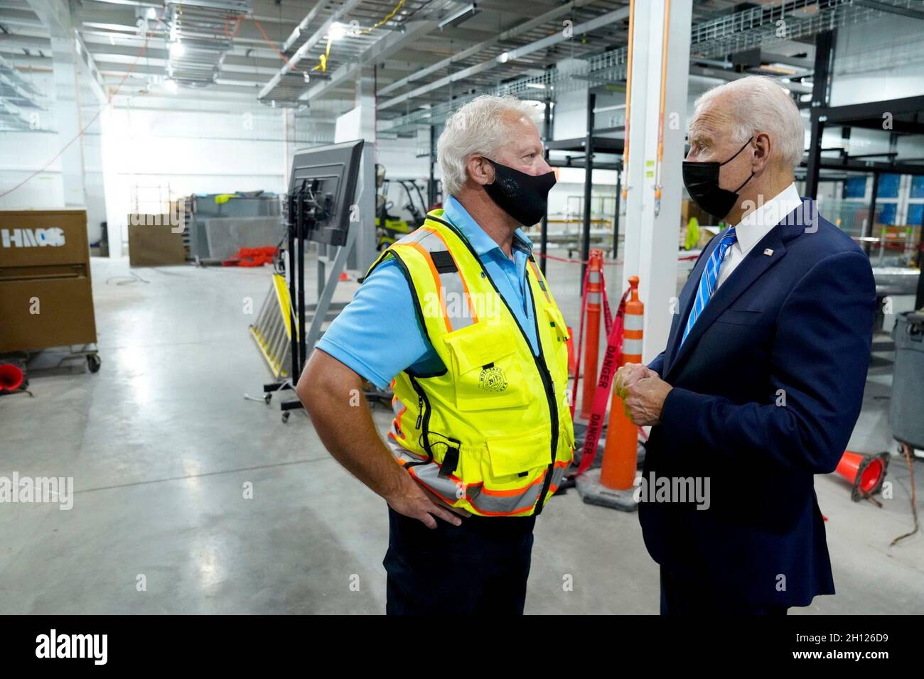 Elk Grove Village, Vereinigte Staaten von Amerika. 07. Oktober 2021. US-Präsident Joe Biden unternimmt einen Chat mit Jerry Wenzel, Clayco Senior Operations Manager, während eines Besuchs auf einer Baustelle der Clayco Corporation, auf der am 7. Oktober 2021 in Elk Grove Village, Illinois, ein Microsoft-Rechenzentrum errichtet wird. Bild: Adam Schultz/White House Photo/Alamy Live News Stockfoto