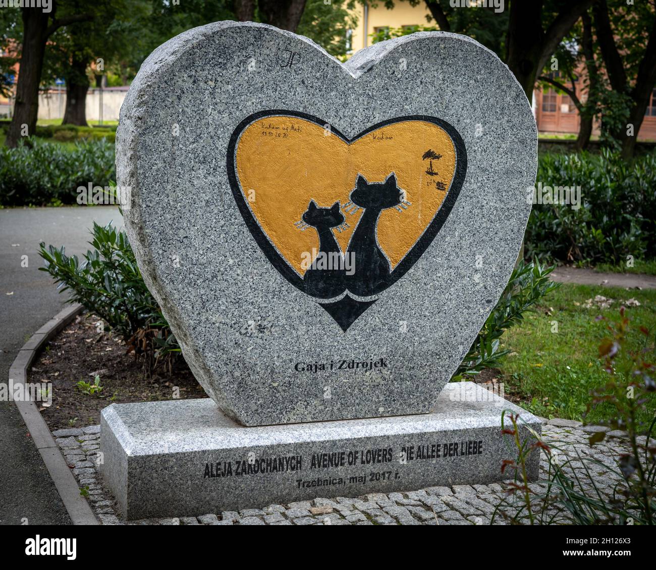 Trzebnica, Polen - 29. August 2021: Ein herzförmiges Steindenkmal eines Katzenpaares "Gaja und Zdrojek", das sich im öffentlichen Park befindet. Stockfoto