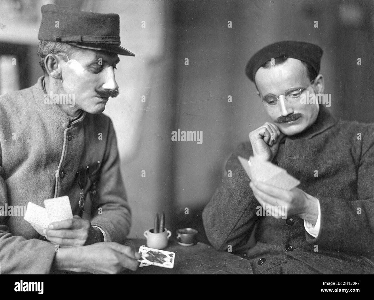 Zwei französische Soldaten, deren Gesichter im Ersten Weltkrieg verstümmelt wurden, trugen Masken, die im Studio des amerikanischen Roten Kreuzes von Anna Coleman Ladd, 1918, angefertigt wurden. Stockfoto
