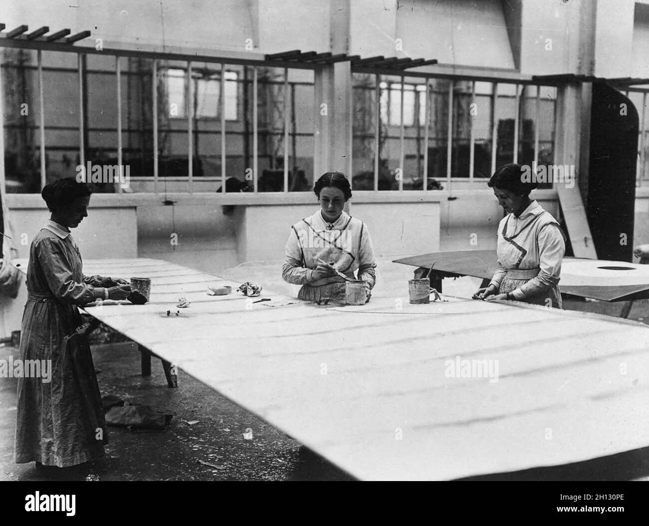 Während des 1. Weltkrieges bauen und behandeln Arbeiter Flugzeugflügel in einer Fabrik. Stockfoto