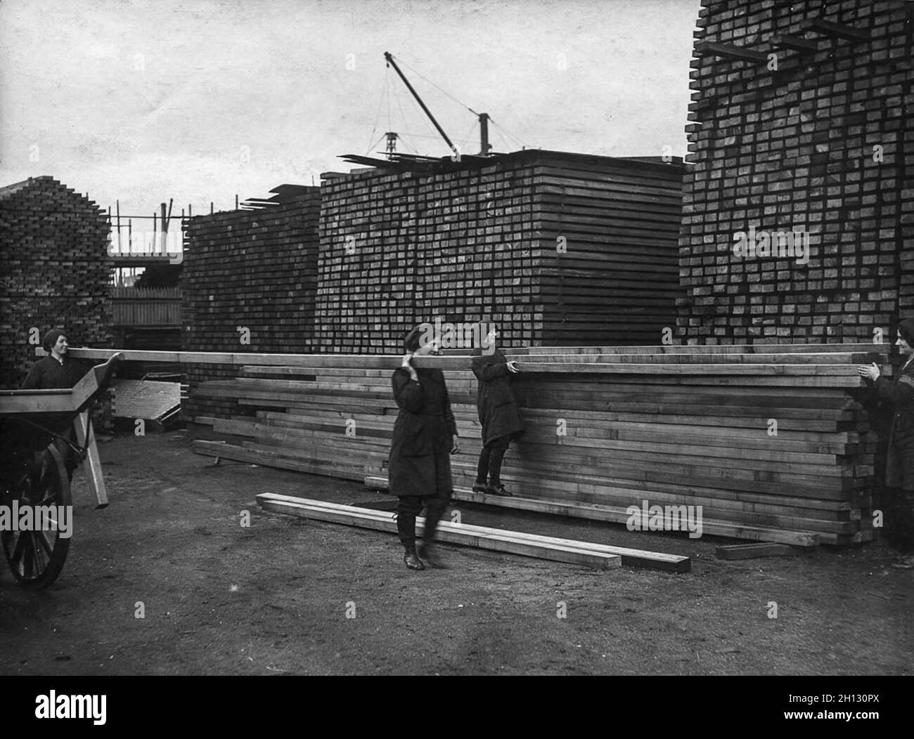 Während des 1. Weltkrieges schleppen Arbeiter Holz in einem Holzhof Stockfoto