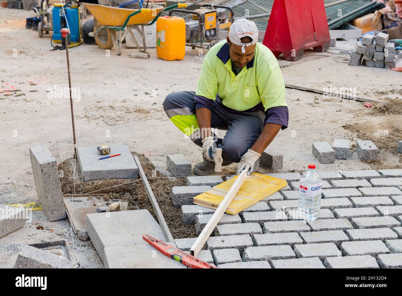 Ein Arbeiter sah, wie er Ziegelsteine während der Sanierung der Plaza legte.die Umgestaltung der Plaza de la Ciudad de Brujas ist eines der wichtigsten Projekte in der Stadt Valencia, da sie die Stadterneuerung eines Gebiets ermöglicht, das um drei Kulturgüter entwickelt wurde Interesse, wie die Llotja de la Seda, der Central Market und die Kirche von Sant Joan del Mercado. Dieses Projekt wird die Umwelt in einen einheitlichen, komplexen Raum verwandeln und sie in eine Fußgängerzone verwandeln, die 20,000m² Stadtland für die Bürger wiederherstellt. Die städtische Intervention, um dieses Gebiet zu regenerieren, hat eine Knospe Stockfoto