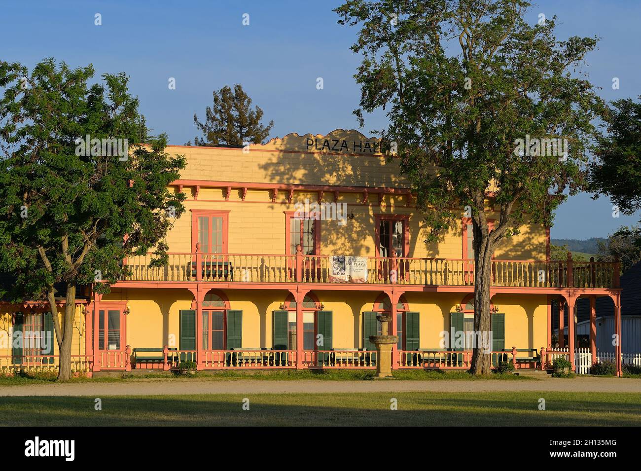 Ein glühender Sonnenuntergang in der Plaza Hall neben der historischen Mission San Juan Bautista CA Stockfoto