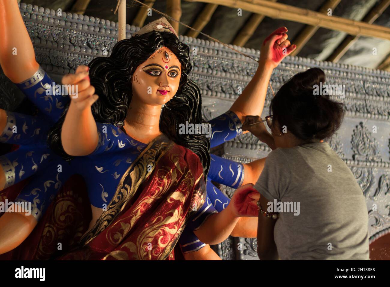 Eine Künstlerin, die das durga-Idol schmückt, das für durga puja, das größte Festival von Westbengalen, gemacht wurde. Stockfoto