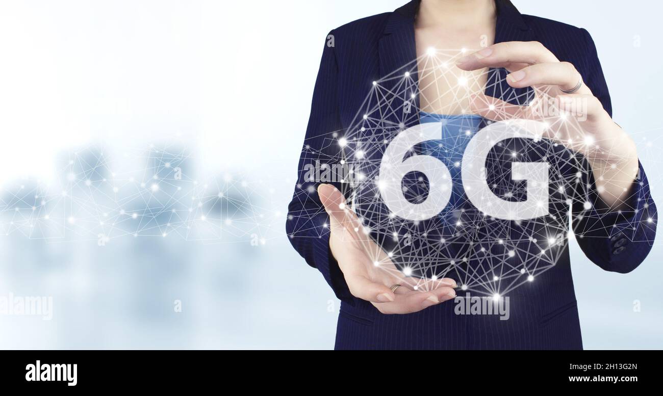6G Network Internet Mobile Wireless Business Concept. Virtuelles holographisches 6G-Symbol mit zwei Händen und hellem unscharfem Hintergrund. Abstrakte Welt netwo Stockfoto