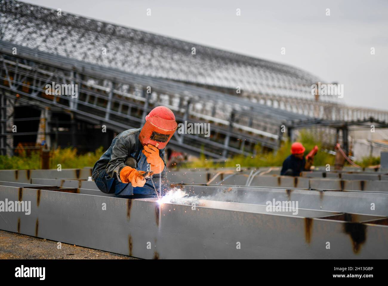 (211016) -- QIAN'AN, 16. Oktober 2021 (Xinhua) -- Ein Arbeiter schweißt Baumaterialien auf der Baustelle eines "Road-to-Rail"-Projekts in Qian'an ctiy, nordchinesische Provinz Hebei, 16. September 2021. Qian'an in der Provinz Hebei ist ein wichtiger Landkreis in der Stahlindustrie in Nordchina, mit einer großen Transportnachfrage nach Rohstoffen wie Eisenerz, Kohle und Koks. Um die Umweltverschmutzung und die Verkehrsstaus durch den Straßentransport von Massengütern zu verringern, wurden spezielle Eisenbahnlinien für wichtige Eisen- und Stahlunternehmen im Rahmen eines „Road-to-Rail“-Systems gebaut, das den Weg für ein g ebnete Stockfoto