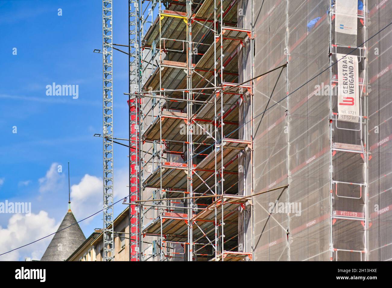 Karlsruhe, Deutschland - August 2021: Teil der Baustelle mit Gerüsten auf mehrgeschossiger Gebäudefassade während der Renovierung Stockfoto