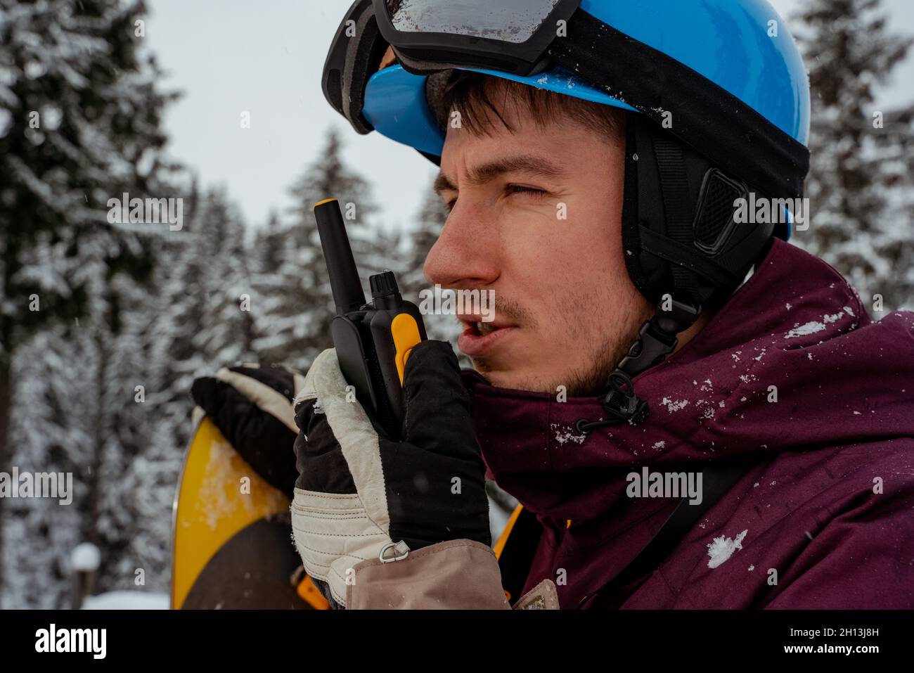 Mann in Skiausrüstung, trägt eine Schutzbrille und spricht auf Walkie-Talkie.  Auf der Suche nach Powder bis zum Freeride Stockfotografie - Alamy