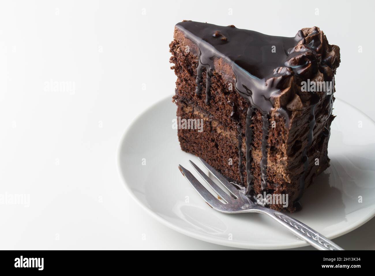 Stück Schokoladenkuchen auf Weiß mit Kuchengabel und Platz für Text Stockfoto