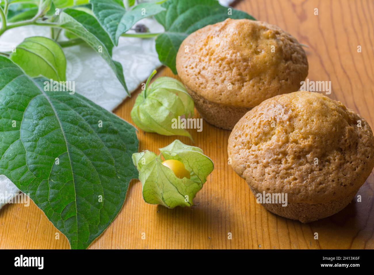 Stachelbeeren-Muffins auf rustikalem Tisch Stachelbeeren im Vordergrund Stockfoto
