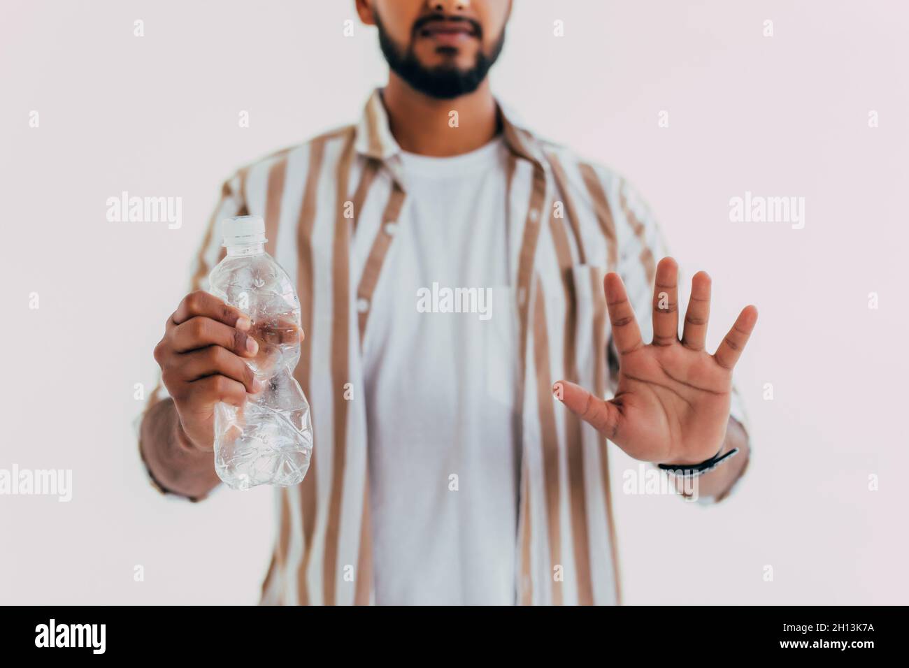 Sagen Sie keine Plastikflasche. Konzept. Der Mensch sagt Nein zur Plastikflasche. Keine Verschwendung. Umwelt. Handbewegung, um Vorschlag Plastikflasche abzulehnen. Hält Flasche und Stockfoto