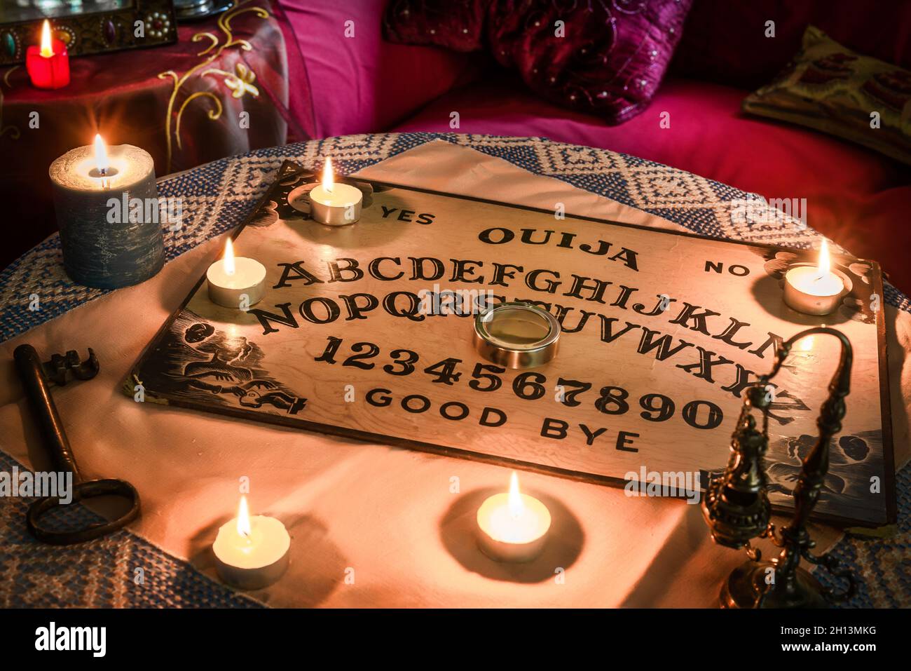 Spiritismus-Tisch mit einem Ouija-Brett und vielen brennenden Kerzen.  Esoterischer Seance an Halloween Stockfotografie - Alamy