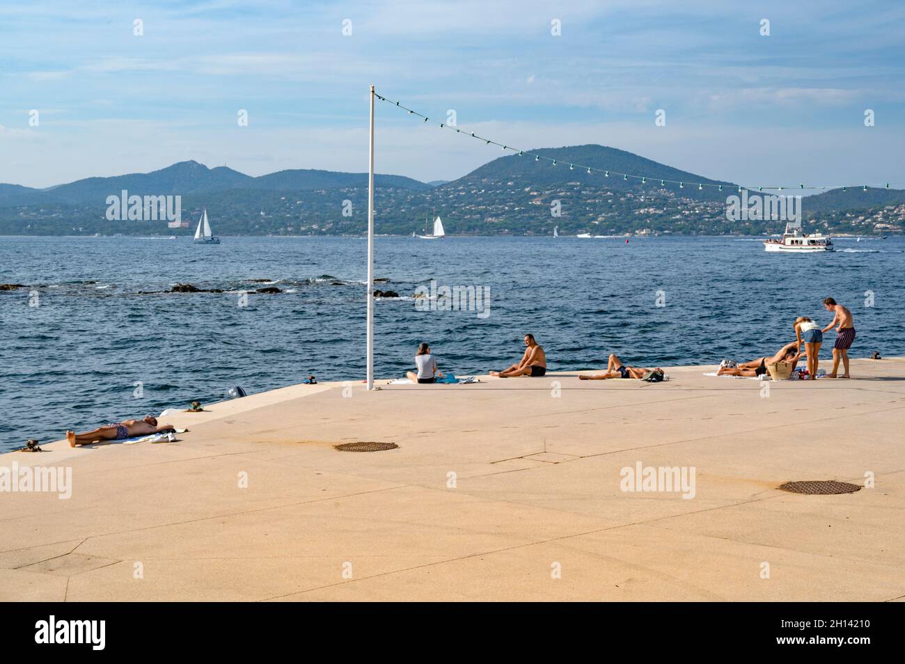 Menschen, die sich sonnen und den Blick über die Bucht von Saint-Tropez, Frankreich, genießen Stockfoto