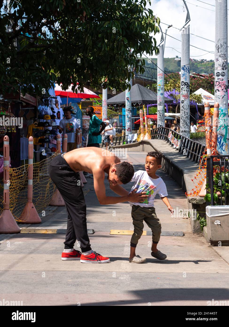 Medellin, Antioquia, Kolumbien - Dezember 23 2020: Ein junger Vater mit seinem Sohn spielt in Commune 13, einer touristischen Nachbarschaft Stockfoto