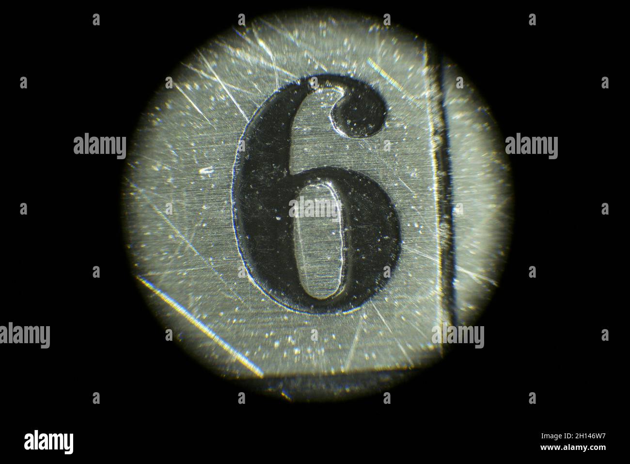 Mikroskopische Ansicht der schwarzen Zahl 6 auf Metallskala Stockfoto
