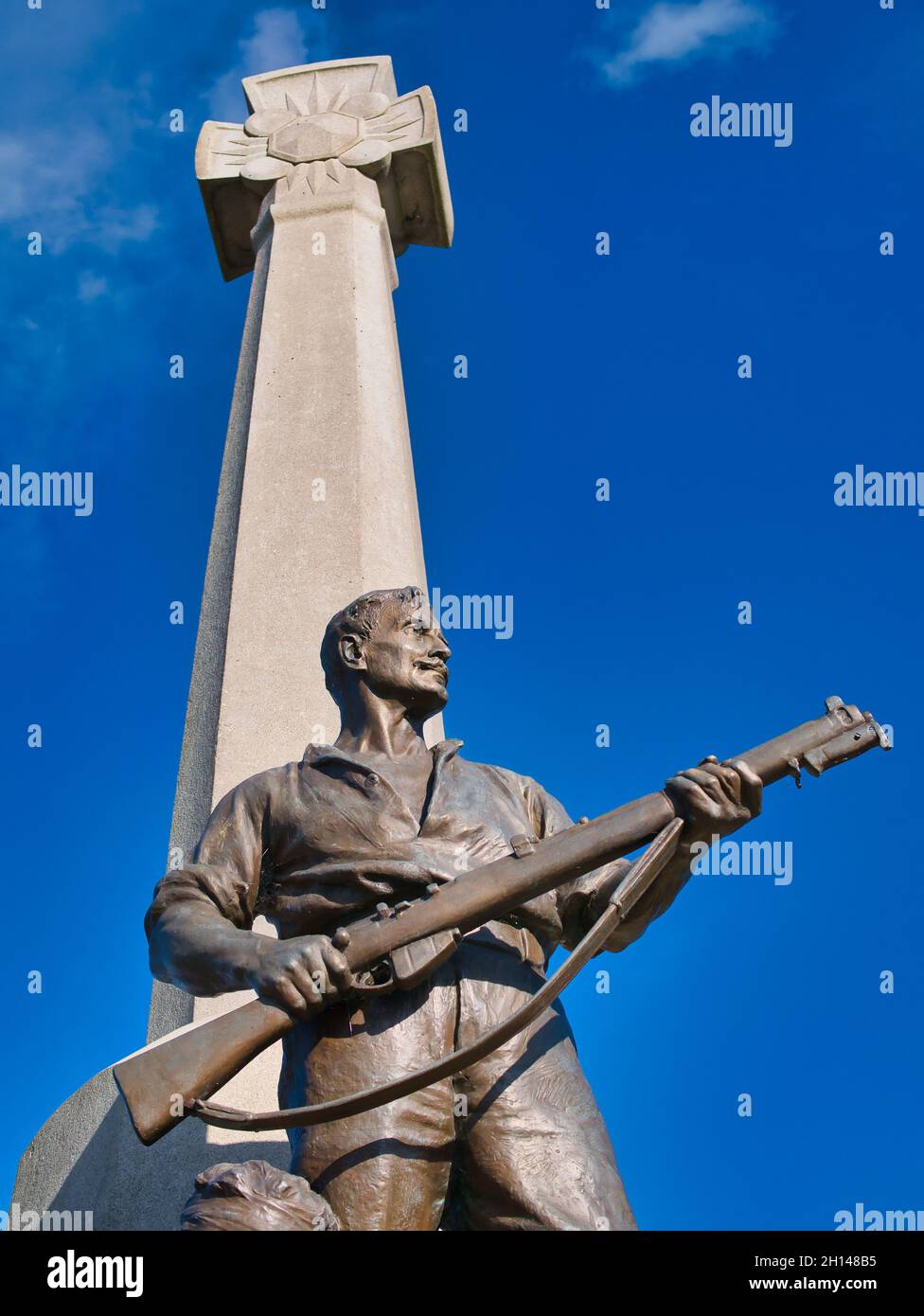 Die Bronzefigur eines Soldaten und Gewehr mit Runenkreuz hinter dem Port Sunlight war Memorial von Sir William Goscombe John. Stockfoto