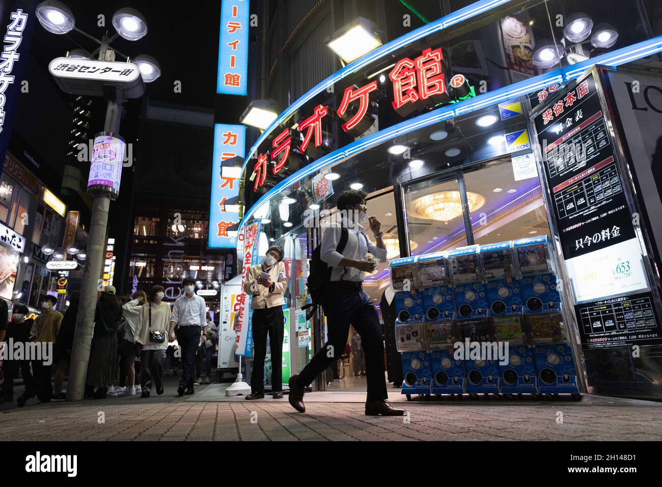Ein Mann mit Gesichtsmaske geht an einem Karaoke-Salon im Shibuya-Viertel in Tokio vorbei.das Nachtleben im Unterhaltungsviertel von Tokio Shibuya kehrt wieder zur Normalität zurück, nachdem der mit dem Coronavirus verbundene Ausnahmezustand in Tokio aufgehoben wurde. Restaurants und Bars können abends geöffnet sein und wieder Alkohol servieren. (Foto von Stanislav Kogiku / SOPA Images/Sipa USA) Stockfoto