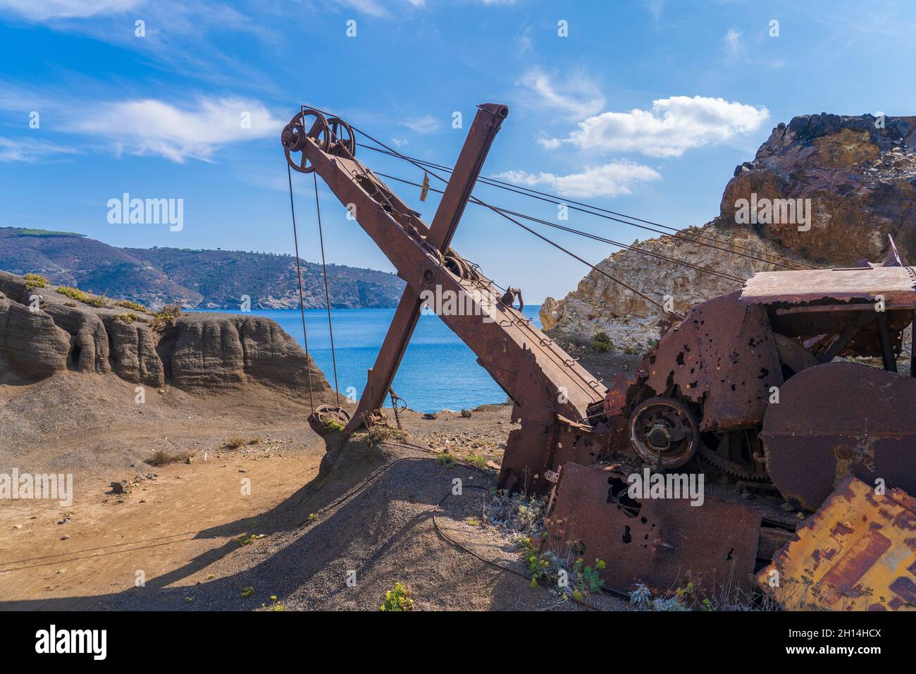 Nette aktive Frau, die ihr elektrisches Mountainbike in den verlassenen Eisenerzminen der Halbinsel Calamite auf der Insel Elba, Toskanischer Archipel, T reitet Stockfoto