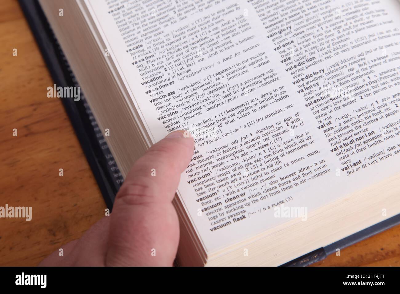 Looking up word in dictionary Fotos und Bildmaterial in hoher