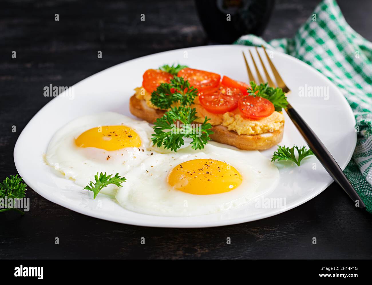 Spiegeleier und ein gegrilltes Hähnchenpastete-Sandwich auf dunklem Hintergrund. Stockfoto