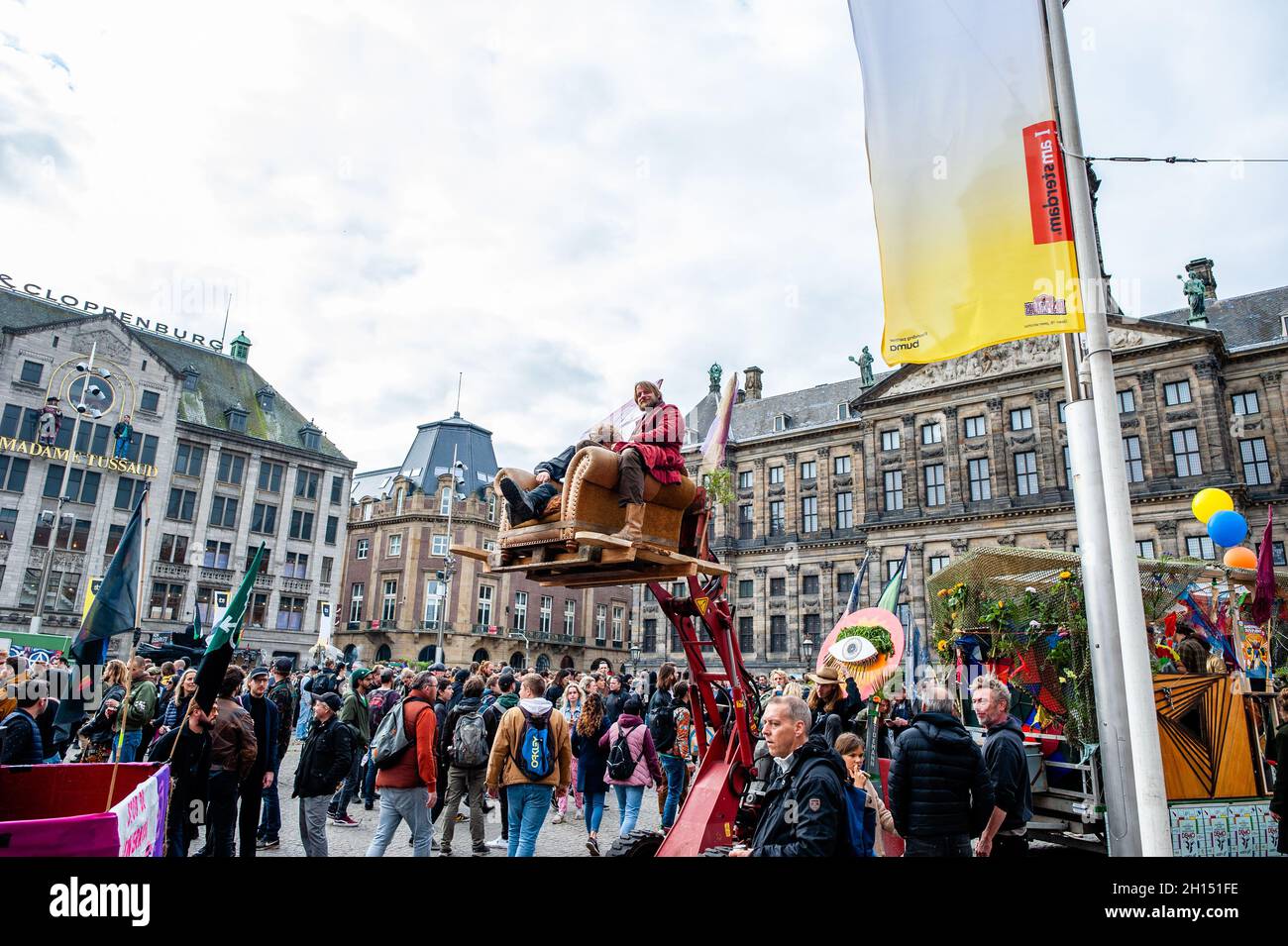 Amsterdam, Niederlande. Oktober 2021. Während der Kundgebung sitzen zwei Männer auf einem kleinen Bus, der auf einem Kran steht.Tausende von Menschen tanzten in Begleitung von Lastwagen mit lauter Musik durch das Zentrum von Amsterdam. ADEV (Amsterdam Danst Ergens voor) bedeutet „Amsterdam tanzt für irgendwo“. Jedes Jahr tanzen die ADEV-Demonstranten für kreative Freiräume in der Stadt. In diesem Jahr protestieren sie auch gegen die Wohnungskrise, deshalb war das Thema Stopp des Monopoly-Spiels in Amsterdam. (Foto: Ana Fernandez/SOPA Images/Sipa USA) Quelle: SIPA USA/Alamy Live News Stockfoto