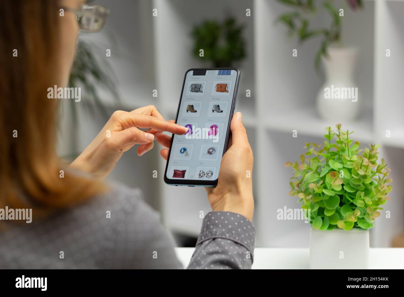 Frau mit Smartphone kauft online. E-Commerce über ein Mobiltelefon. Einkaufen. Stockfoto