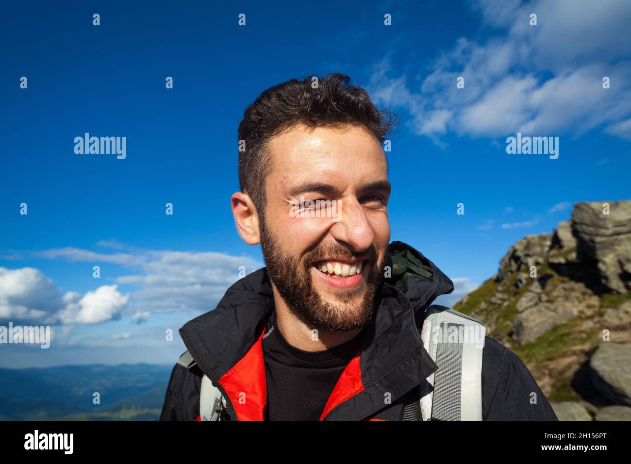 Porträt eines fröhlichen Mannes in Trekkingkleidung, der blinkt Stockfoto