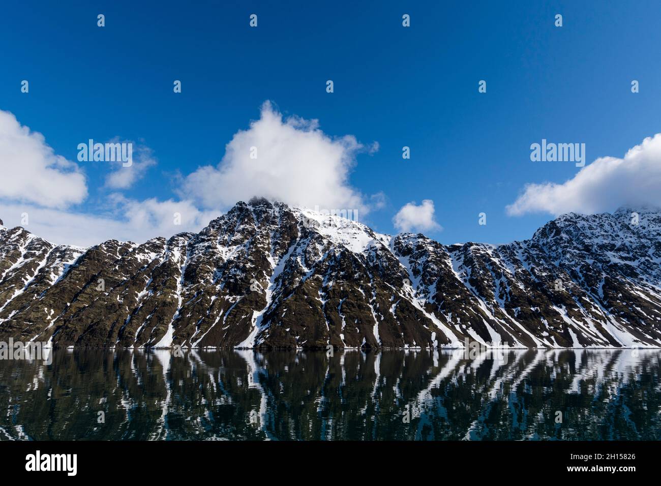 Die Berge spiegeln sich in den Gewässern des Krossfjords wider. Spitzbergen, Spitzbergen, Norwegen Stockfoto