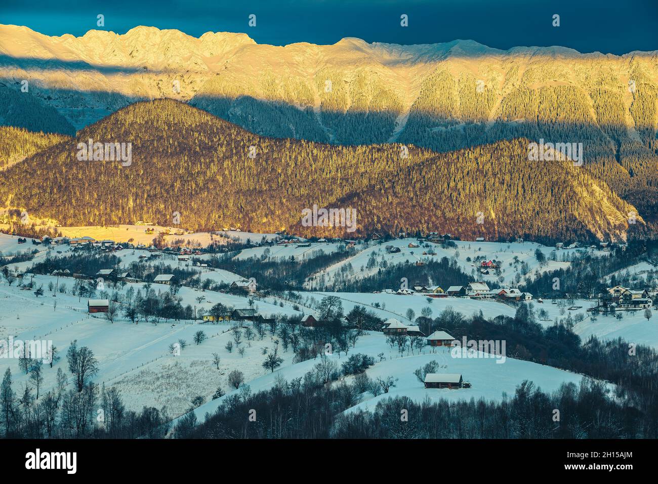 Erstaunliche Wintermorgendlandschaft mit malerischen verschneiten Bergen. Wunderschöner Sonnenaufgang und verschneite Bergrücken im Hintergrund, Piatra Craiului Berge Stockfoto