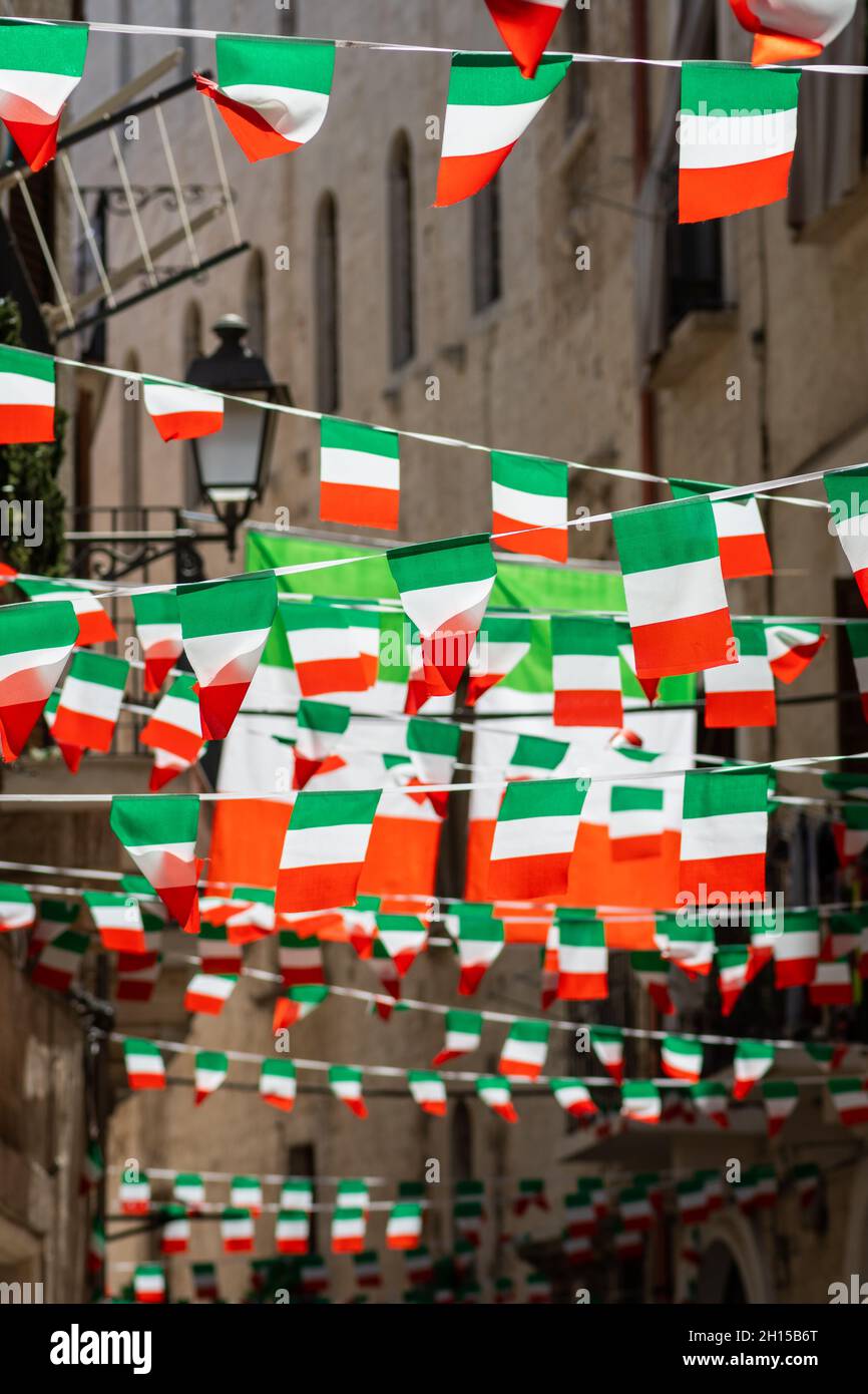 Italienische Flaggen und Wimpel in einer engen Altstadt einer Stadt in Italien Stockfoto