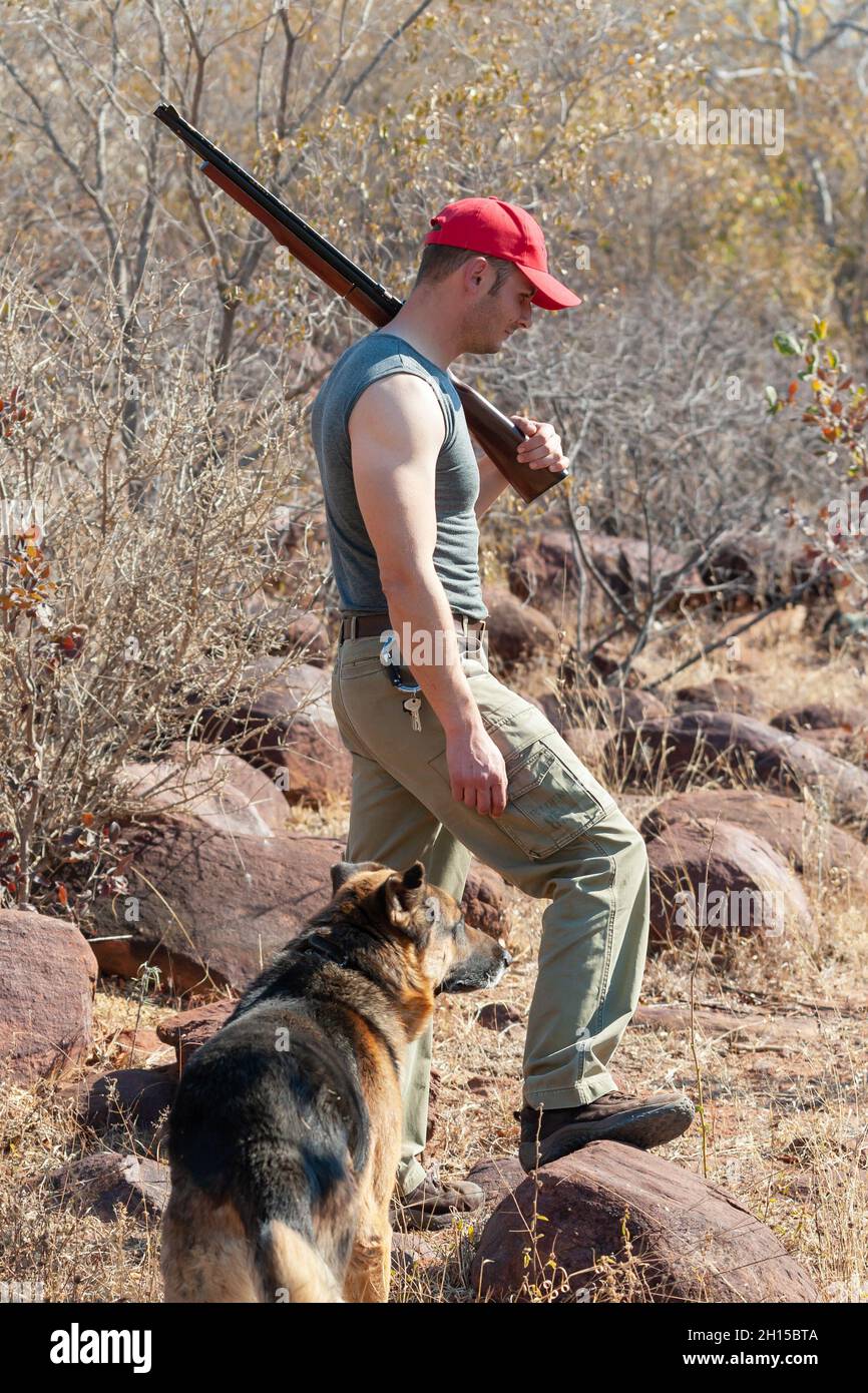 Kaukasischer südafrikanischer Jäger im Busch mit seinem Hund, Stockfoto