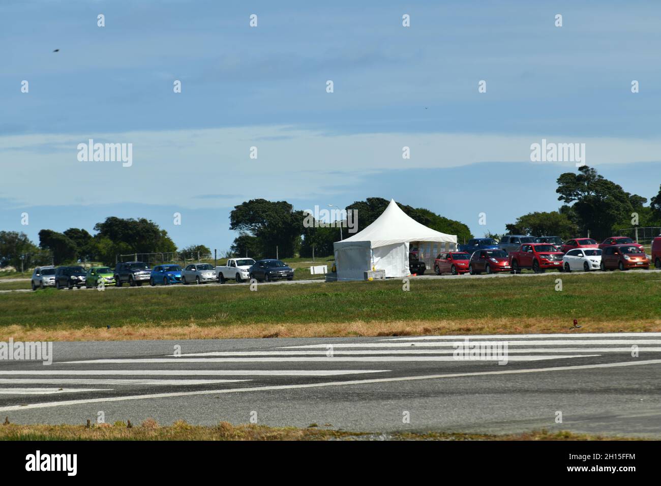 GREYMOUTH, NEUSEELAND, 16. OKTOBER 2021:Hitzedunst verdunkelt teilweise das Bild von Menschen in Greymouth, die am Super-Samstag wegen der Massenimpfung von Covid am Flughafen Schlange standen. 130,000 wurden landesweit geimpft. Stockfoto