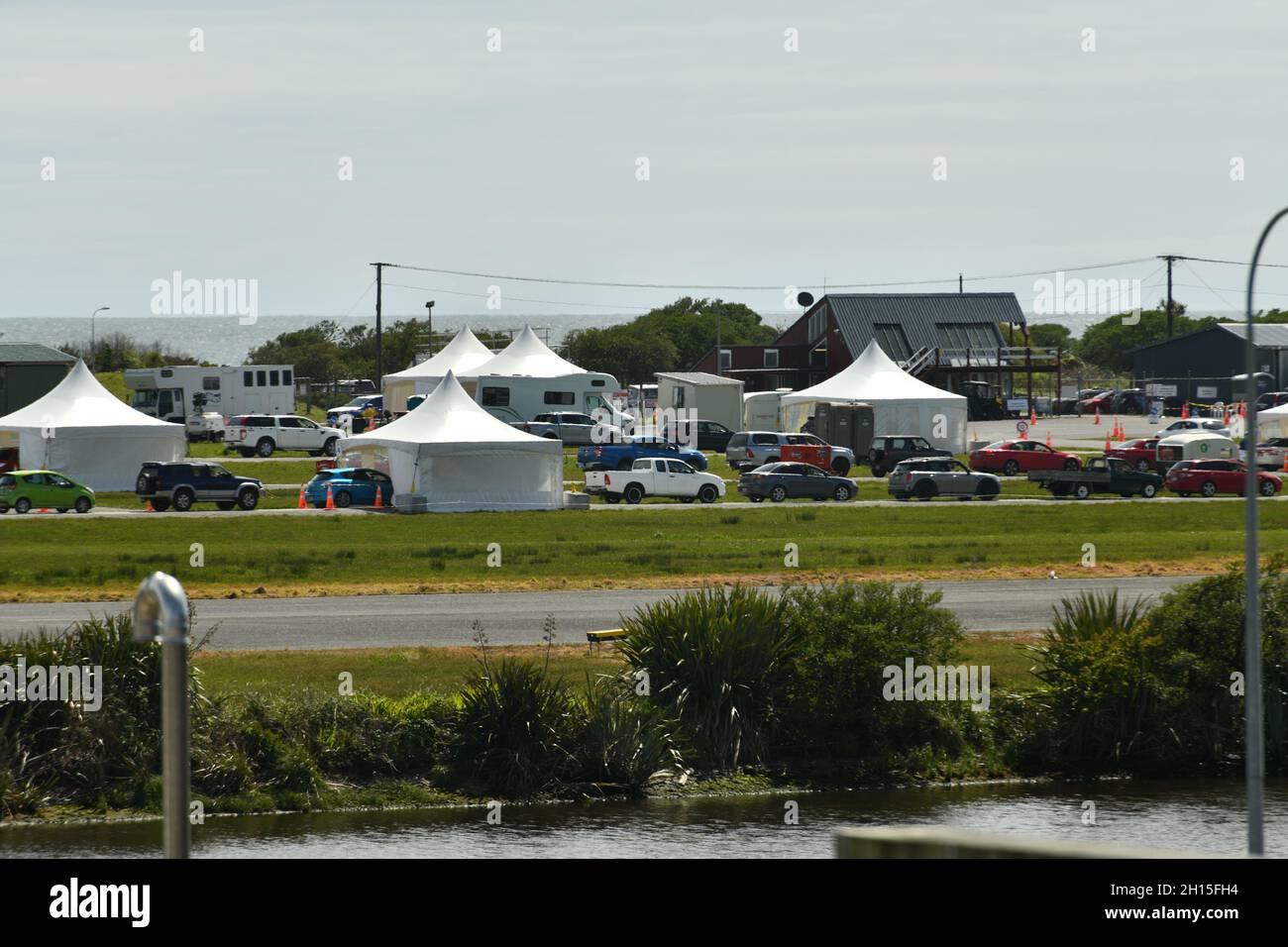 GREYMOUTH, NEUSEELAND, 16. OKTOBER 2021:Hitzedunst verdunkelt teilweise das Bild von Menschen in Greymouth, die am Super-Samstag wegen der Massenimpfung von Covid am Flughafen Schlange standen. 130,000 wurden landesweit geimpft. Stockfoto