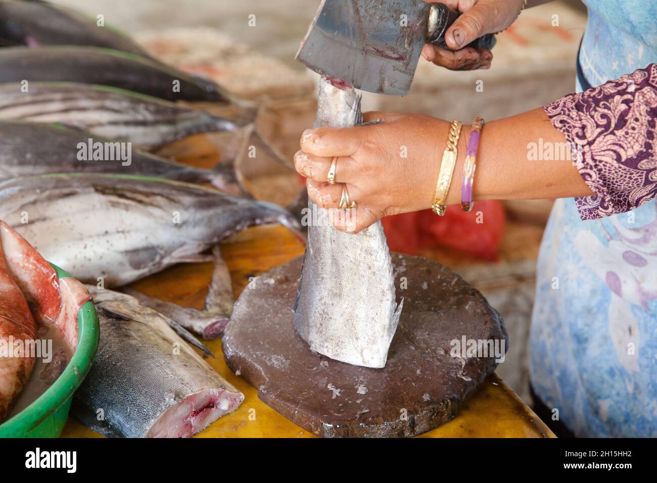 Schneiden Sie Thunfisch auf den Tisch eines Fischverkäufers auf dem Fischmarkt. Roher Thunfisch.der Verkäufer zerschnitt Thunfisch in Stücke. Stockfoto