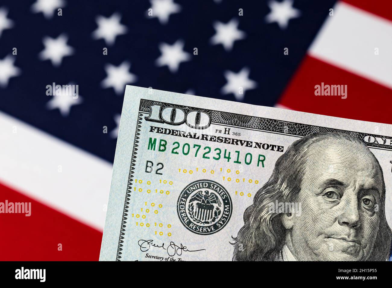 100-Dollar-Schein mit amerikanischer Flagge. Schuldenobergrenze, Aktienmarkt und Finanzkonzept. Stockfoto