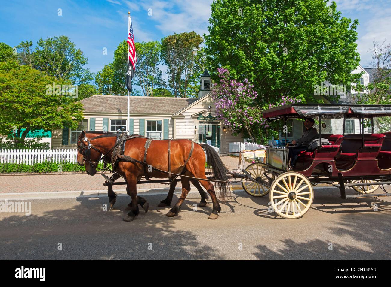 Mackinac Island, Michigan. Eine Pferdekutsche fährt am Postamt vorbei. Stockfoto