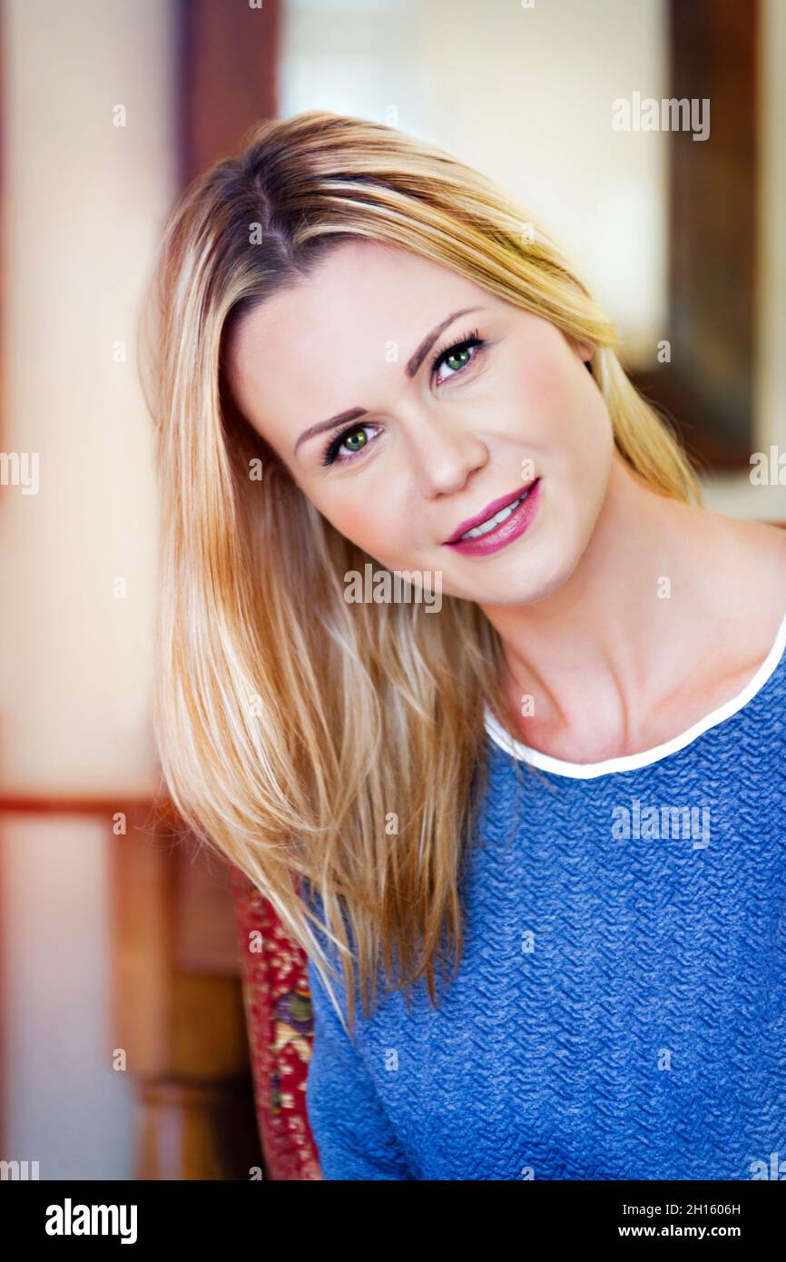 Drinnen Porträt einer schönen jungen blonden Frau in ihrem Haus Stockfoto