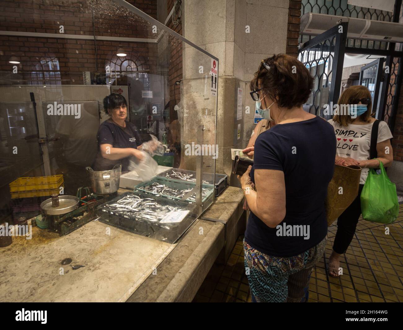 RIJEKA, KROATIEN - 18. JUNI 2021: Selektive Unschärfe bei Frauen, die Fisch und Meeresfrüchte an Kunden in ribarnica verkaufen rijeka der überdachte Fischmarkt, ein Mon Stockfoto