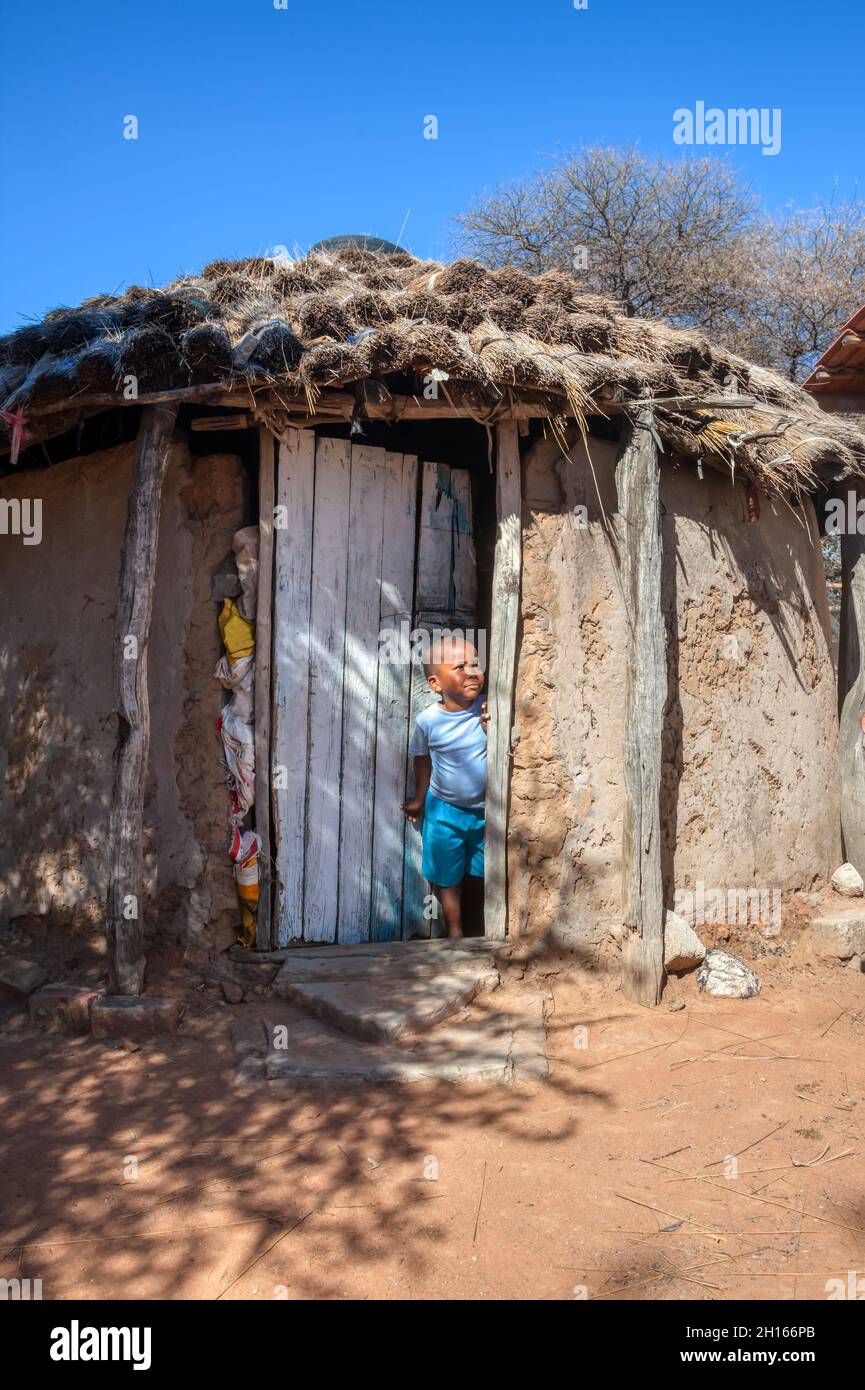 Afrikanisches Kinderporträt in einem Dorf im ländlichen Botswana, das vor dem Haus steht Stockfoto