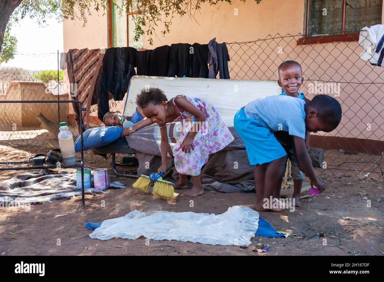 Tägliches afrikanisches Leben in einem Dorf im ländlichen Botswana, Kinder spielen auf dem Hof Stockfoto