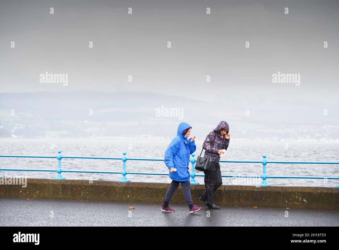 Greenock, Inverclyde, Schottland, Großbritannien, 2. Oktober 2021, Ältere Frauen, die während des feuchten britischen Sommers in Großbritannien bei starkem Regen zu Fuß gehen Stockfoto